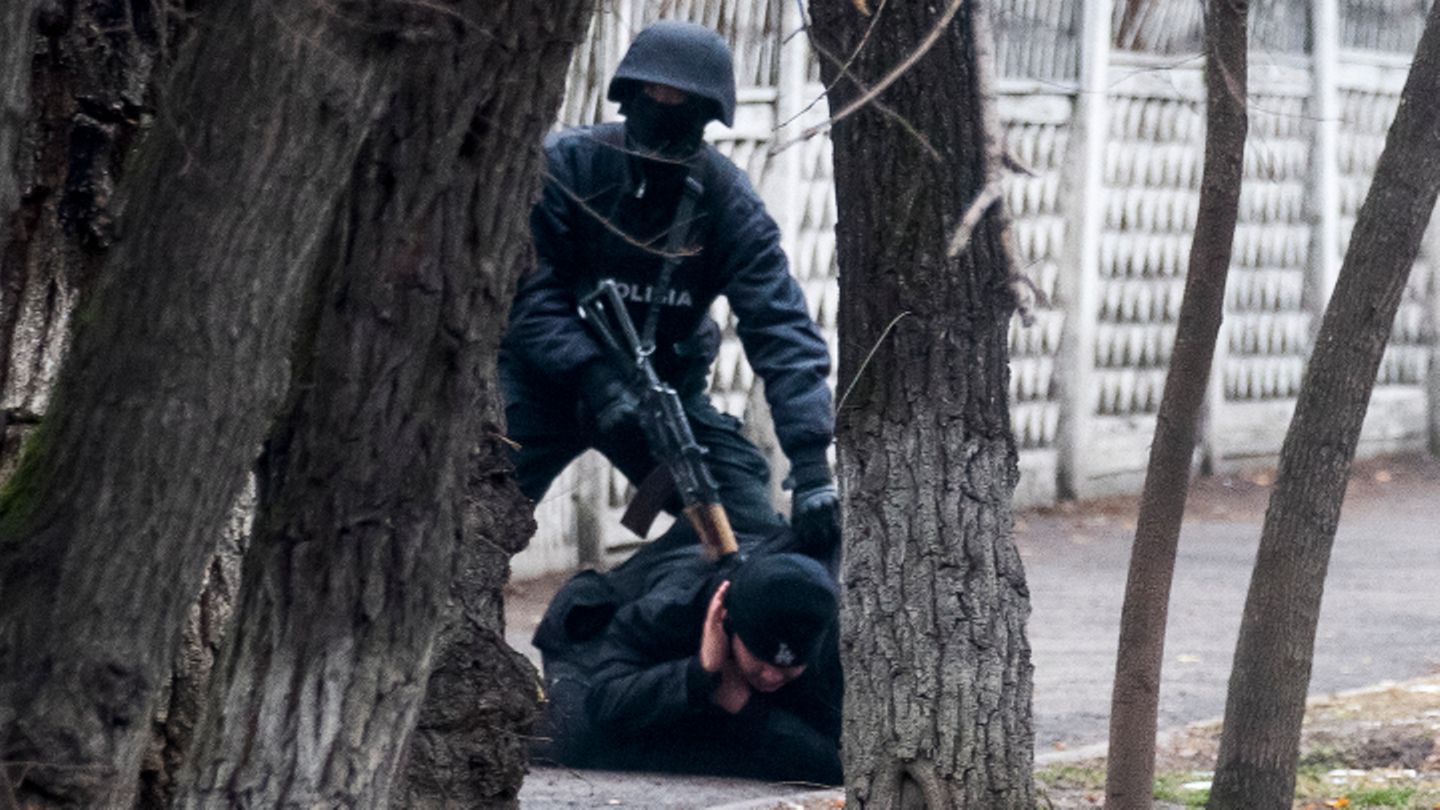 Almaty, Kasachstan: Ein bewaffneter Polizist hält einen Demonstranten inmitten der Unruhen auf dem Boden fest.