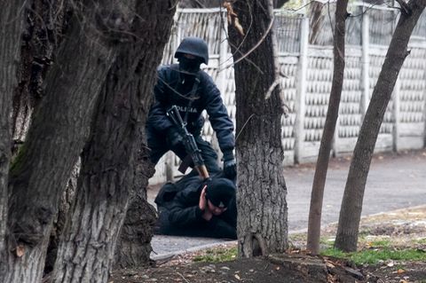 Almaty, Kasachstan: Ein bewaffneter Polizist hält einen Demonstranten inmitten der Unruhen auf dem Boden fest.