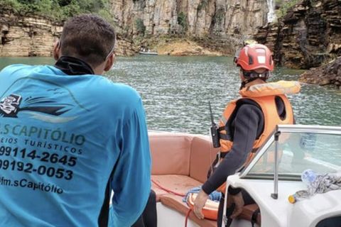 Brasilien: Zwei Menschen blicken von einem Boot aus auf die Felswand, die auf den See heruntergestürzt ist.