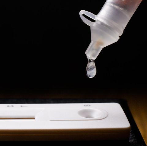 Flüssigkeit wird auf einen Selbsttest für das Coronavirus getröpfelt