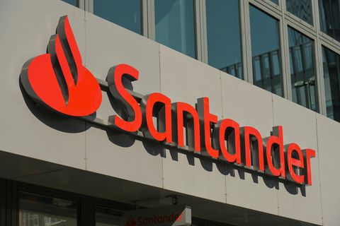 Die Aufschrift "Santander" mit dem Banklogo an einer Geschäftsfassade