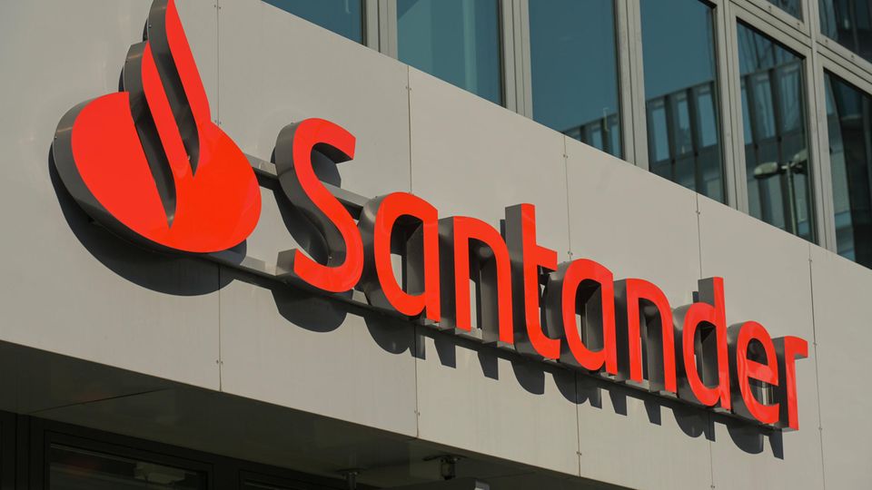 Die Aufschrift "Santander" mit dem Banklogo an einer Geschäftsfassade