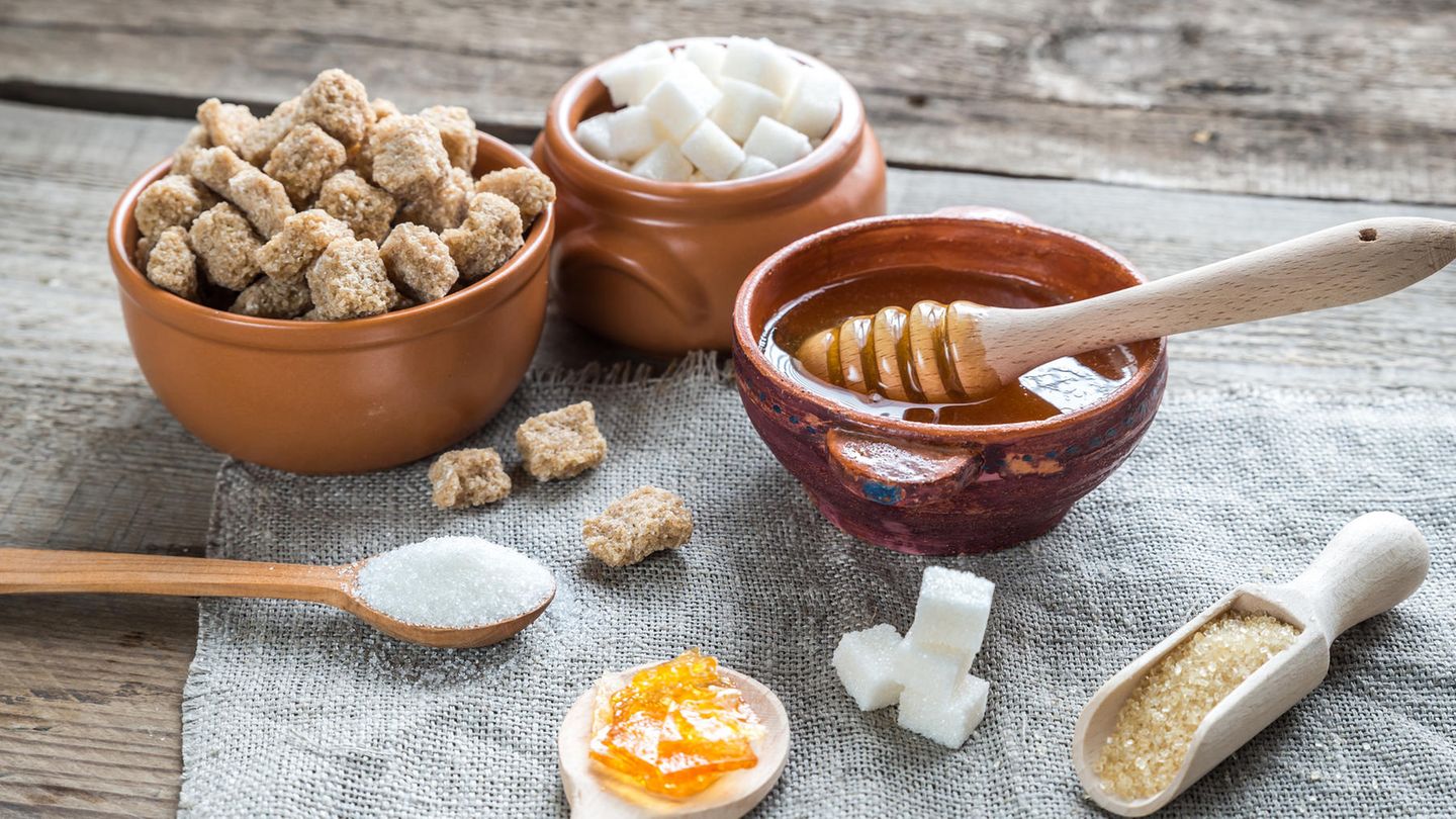 Ein Tisch mit braunem Zucker, weißem Zucker, Honig, Würfelzucker etc.