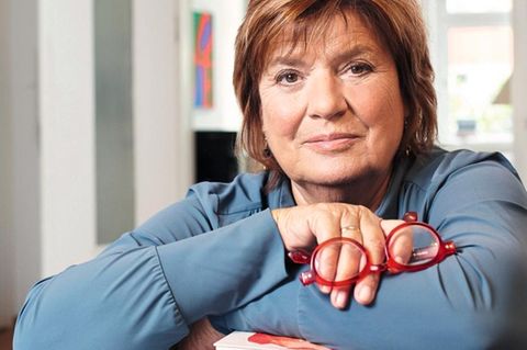 Christine Westermann lehnt sich auf einen Stapel Bücher