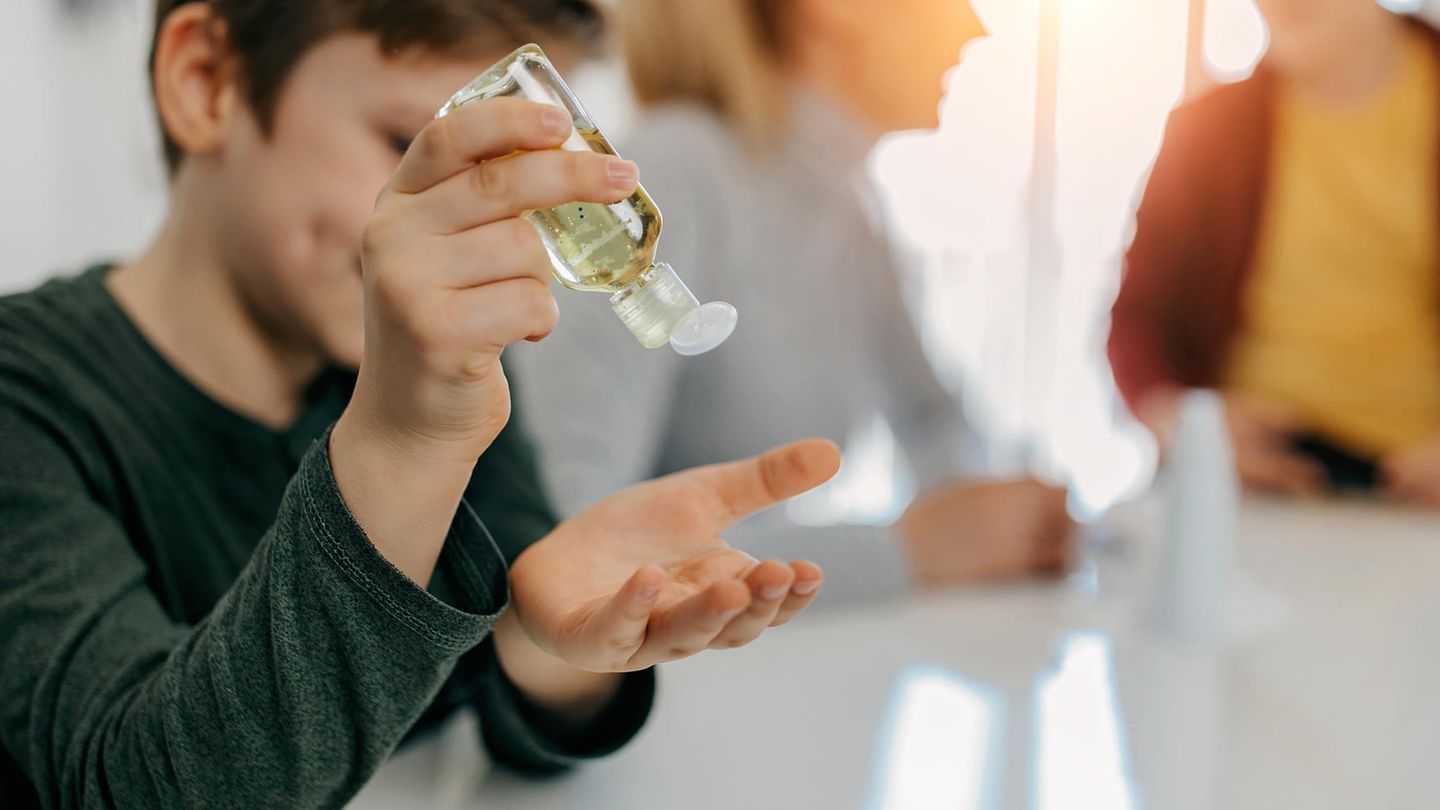 Ein Junge nutzt Desinfektionsmittel