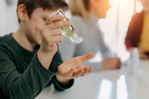 Ein Junge nutzt Desinfektionsmittel