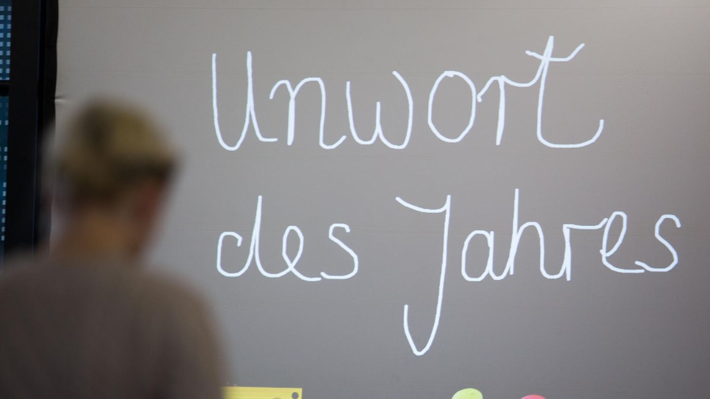 Die Worte "Unwort des Jahres" sind mit Schreibschrift an eine Tafel gemalt