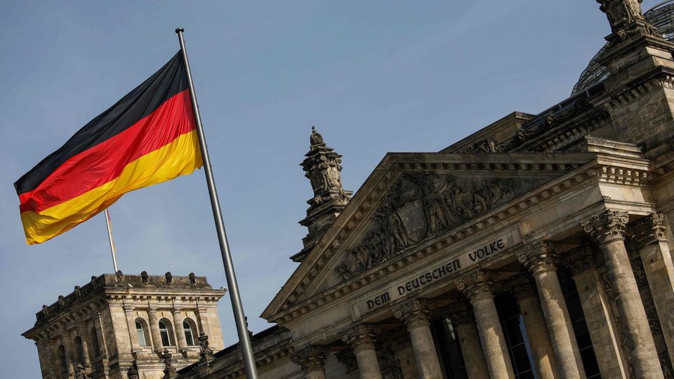Das Reichstagsgebäude von außen. Im Vordergrund die deutsche Flagge