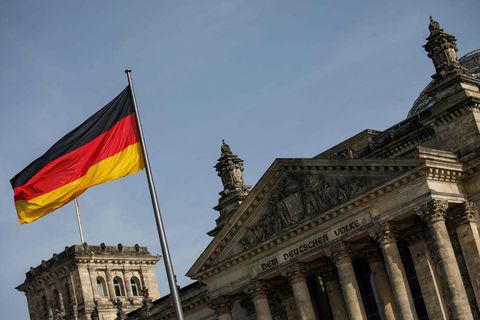 Das Reichstagsgebäude von außen. Im Vordergrund die deutsche Flagge