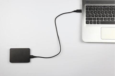 Externe Festplatte 2 TB: Eine externe Festplatte ist mit einem Laptop verbunden.