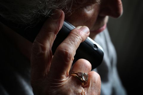 Eine Seniorin hält ein Telefon ans Ohr