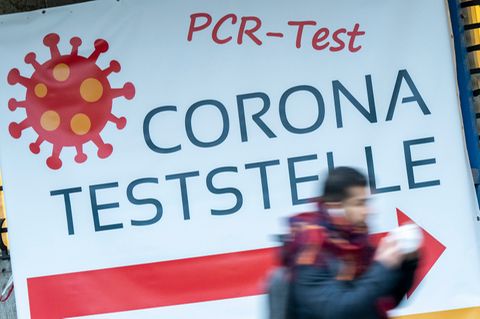 Schilder weisen auf eine PCR-Teststation in München hin