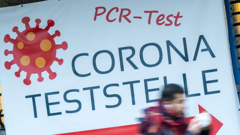 Schilder weisen auf eine PCR-Teststation in München hin