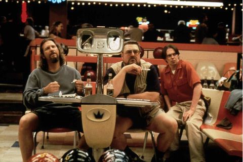 Drei Männer sitzen auf einer Bowlingbahn