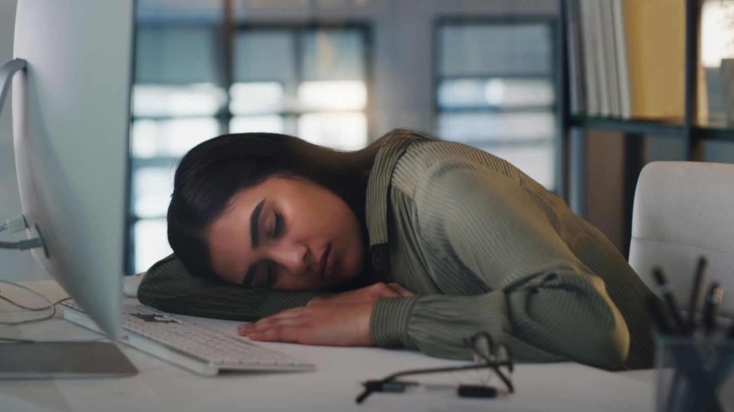 Frau ist auf dem Schreibtisch eingeschlafen