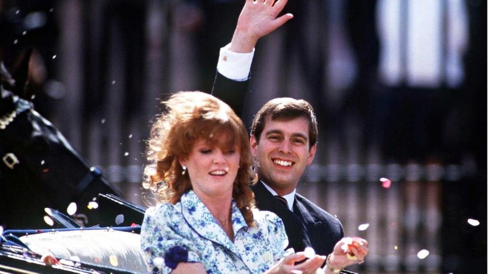 Prinz Andrew als junger Mann winkt aus einem Auto mit seiner Frau