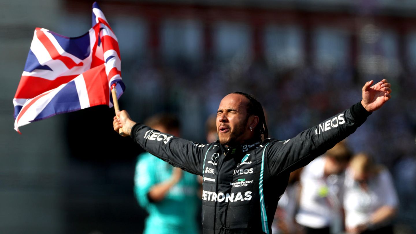 Lewis Hamilton schwenkt einen Union Jack und hat die Augen geschlossen