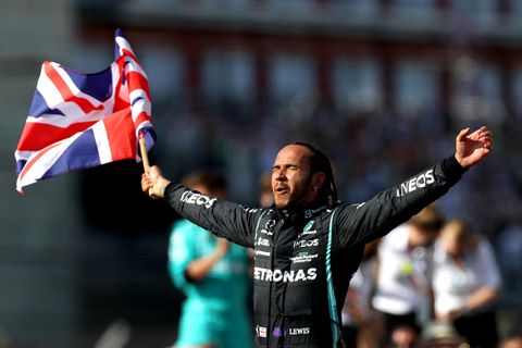 Lewis Hamilton schwenkt einen Union Jack und hat die Augen geschlossen