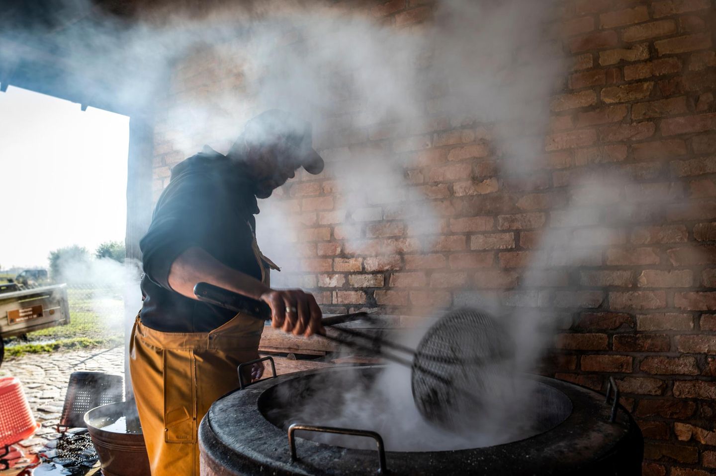 Ein Pferdefischer kocht die Garnelen in einem Kessel mit Salzwasser