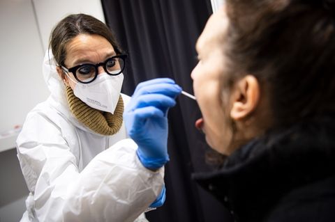 In einem Bremer Testzentrum nimmt eine Mitarbeiterin den Abstrich für einen Coronavirus-Test