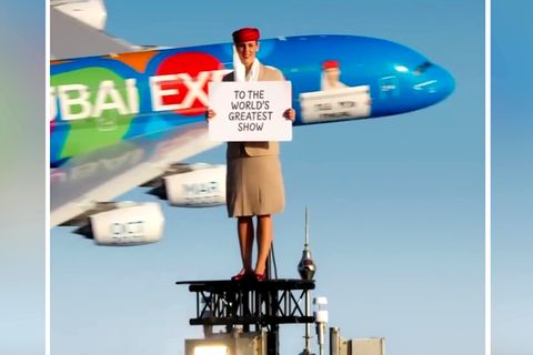 Eine Stuntfrau steht auf dem Burj Khalifa, ein Airbus A380 fliegt an ihr vorbei