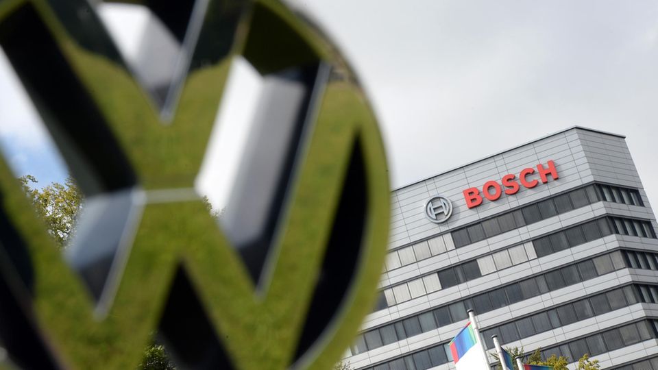Ein VW-Logo wird vor dem Stammsitz von Bosch gehalten.