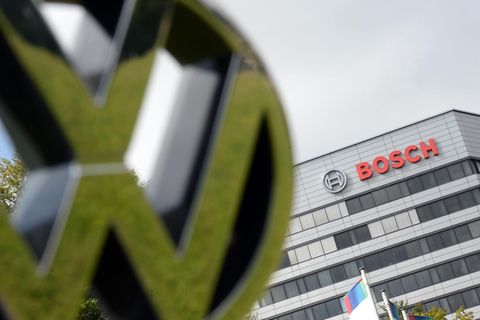 Ein VW-Logo wird vor dem Stammsitz von Bosch gehalten.