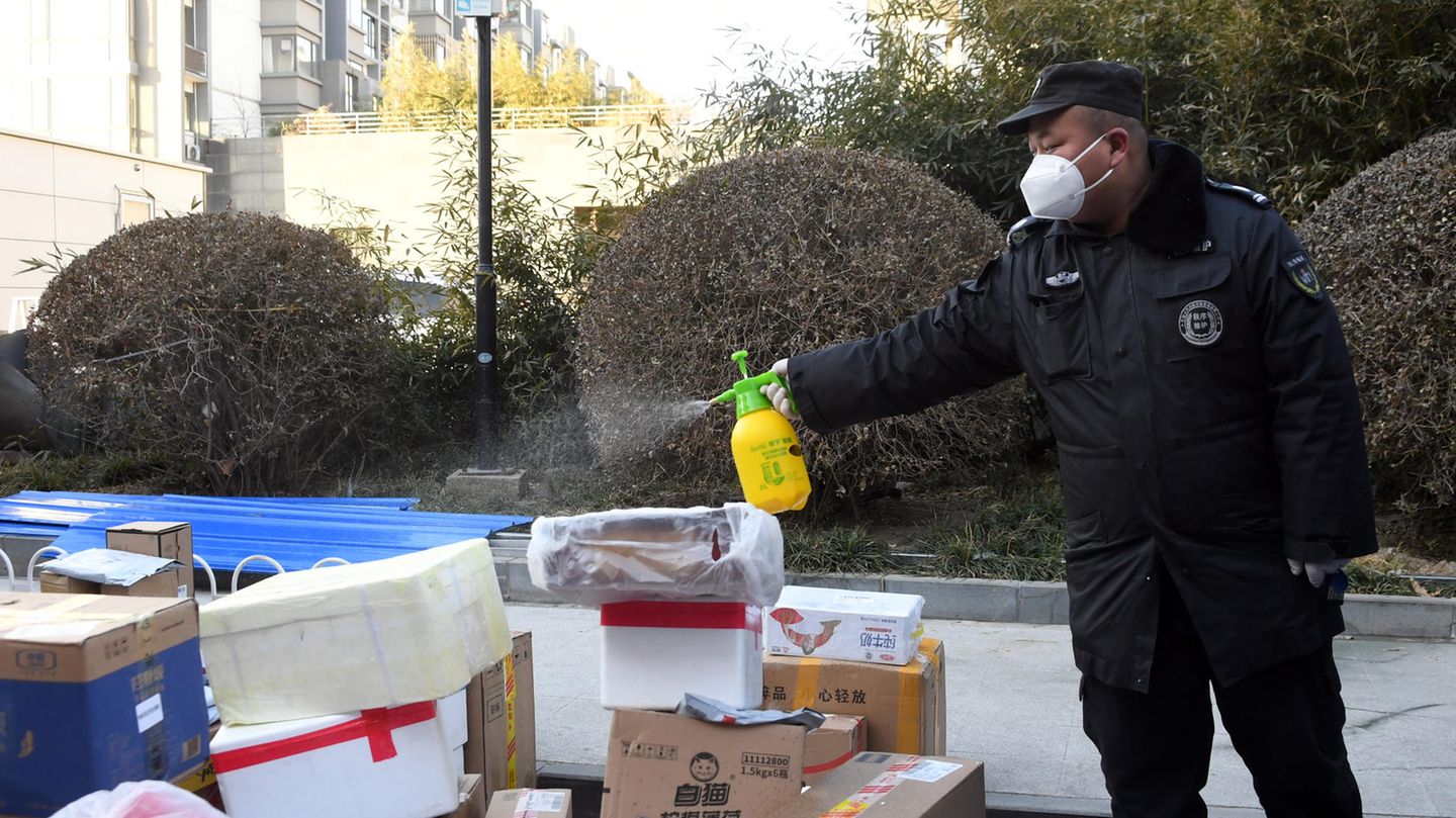 Ein Mitarbeiter desinfiziert Pakete, die an die Bewohner eines Wohngebiets im Haidian-Distrikt von Peking ausgeliefert werden sollen