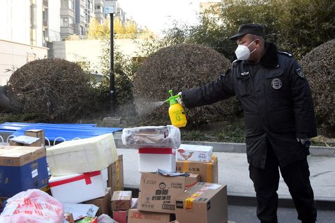 Ein Mitarbeiter desinfiziert Pakete, die an die Bewohner eines Wohngebiets im Haidian-Distrikt von Peking ausgeliefert werden sollen