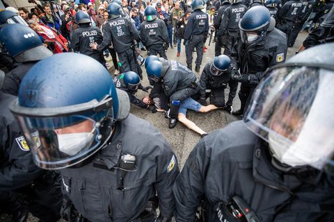 Polizisten nehmen bei einer Demo gegen Coronavirus-Maßnahmen einen Mann fest