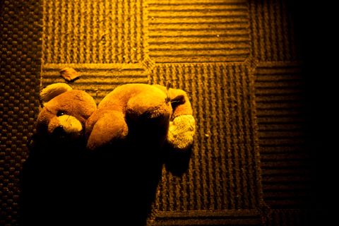 Teddybar liegt auf dem Boden.
