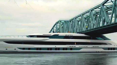 Eine riesige Luxusyacht fährt unter niedriger Brücke hindurch