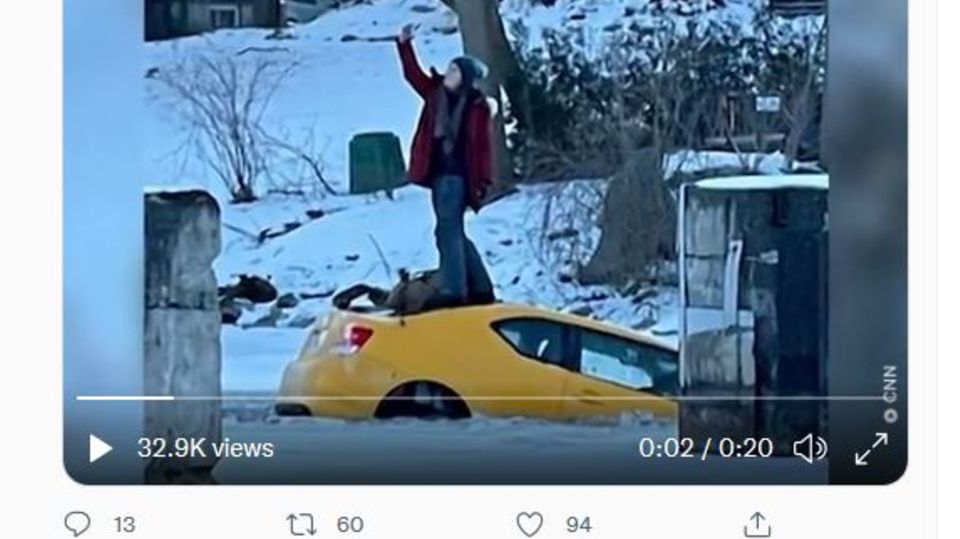 Eine Frau steht auf dem Dach eines gelben Autos und macht ein Selfie