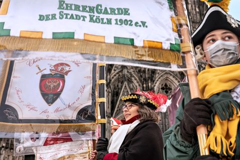 Vor dem Dom warten Fahnenträger auf das Dreigestirn