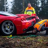 Mitarbeiter vom Abschleppdienst untersuchen den Schaden am Ferrari
