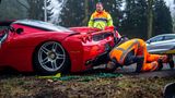 Mitarbeiter vom Abschleppdienst untersuchen den Schaden am Ferrari
