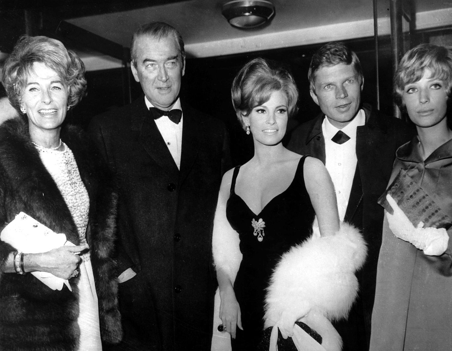 Er gehörte zu den wenigen deutschen Schauspielern, die nach dem Zweiten Weltkrieg international Karriere machen. Dafür änderte er auch seinen Namen und nannte sich nun Hardy Krüger. Er gehörte nun zum Kreis der großen Filmstars. Im Januar 1966 zeigte er sich an der Seite von James Stewart (2.v.l., hier mit seiner Frau Gloria, l) und Raquel Welch (M). Ganz rechts: Krügers zweite Frau Francesca.