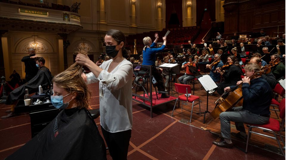 Menschen lassen sich während einer Probe im Konzertsaal in den Niederlanden die Haare schneiden