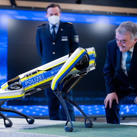Herbert Reul (CDU) schaut sich den Polizeiroboter an