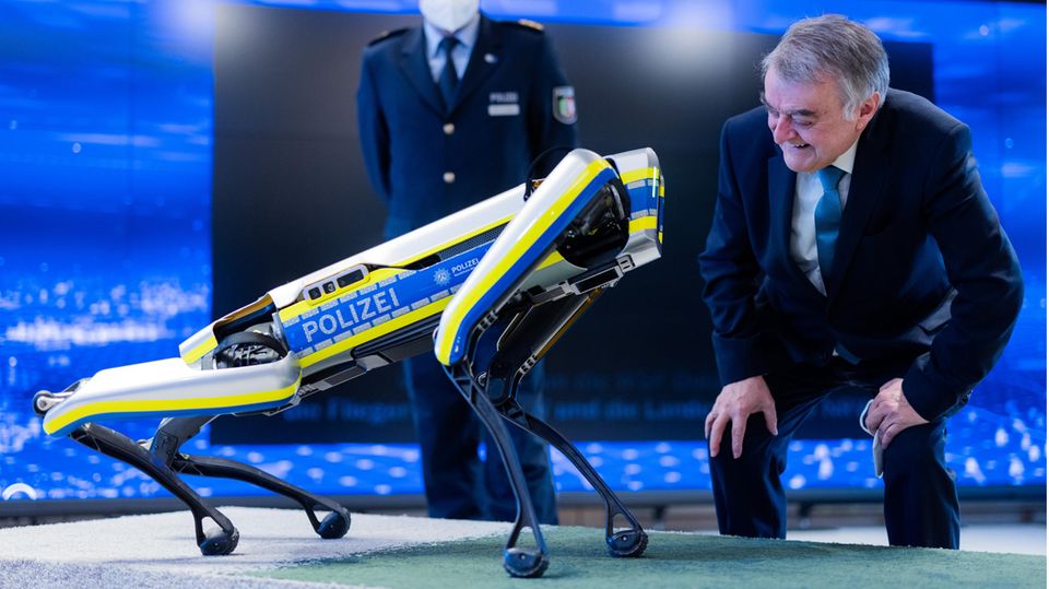 Herbert Reul (CDU) schaut sich den Polizeiroboter an