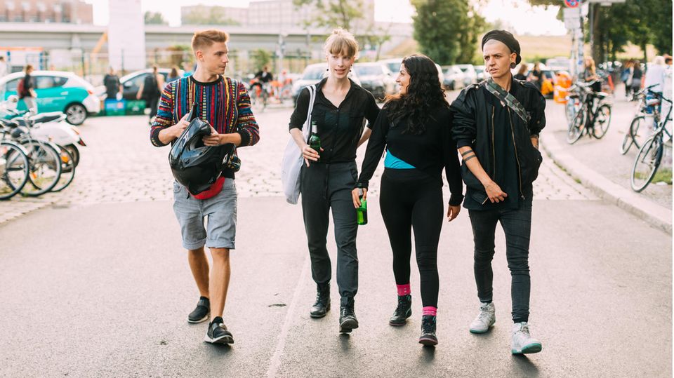 Vier Jugendliche gehen auf einer Straße