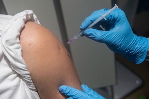 Debatte um Impfpflicht: Eine Impfnadel wird in einen Oberarm gepiekst.