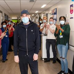 Menschen applaudieren Andrew Watts auf einem Krankenhausflur