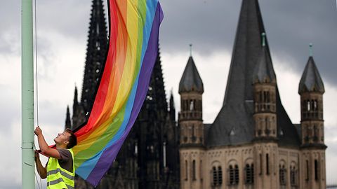 Katholische Kirche unter Druck: Eine Regenbogenfahne vor der Kulisse des Doms und der Kirche Groß St. Martin in Köln (Archiv)