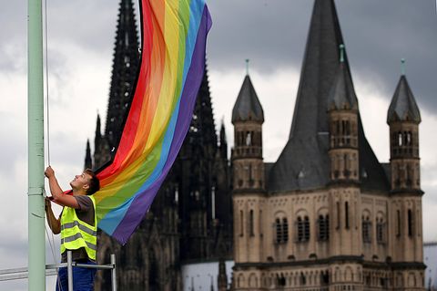 Katholische Kirche unter Druck: Eine Regenbogenfahne vor der Kulisse des Doms und der Kirche Groß St. Martin in Köln (Archiv)