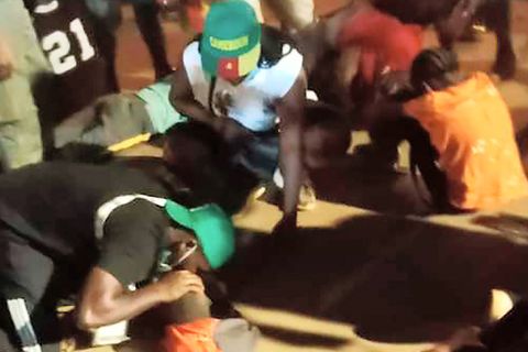 Ersthelfer kümmern sich nach der Panik beim Afrika-Cup vor dem Stadion in Kameruns Hauptstadt Jaunde um Opfer