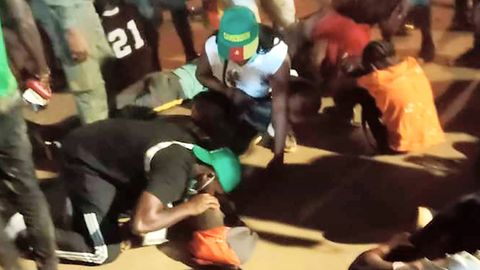 Ersthelfer kümmern sich nach der Panik beim Afrika-Cup vor dem Stadion in Kameruns Hauptstadt Jaunde um Opfer