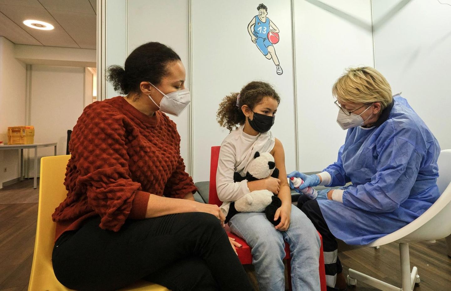 20.12.2021, Bremen, Deutschland - Kinderimpfzentrum betrieben vom ASB und Johanniter-Unfall-Hilfe, Maedchen erwartet die Impfung. 00A211220D009CARO.JPG Eine Ärztin impft ein kleines Mädchen