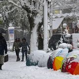 Mit Regenschirmen schützen sich die Bewohner Athens vor dem Schneefall.