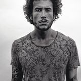 Ein junger Mann mit wuscheligen Locken und starkem Blick